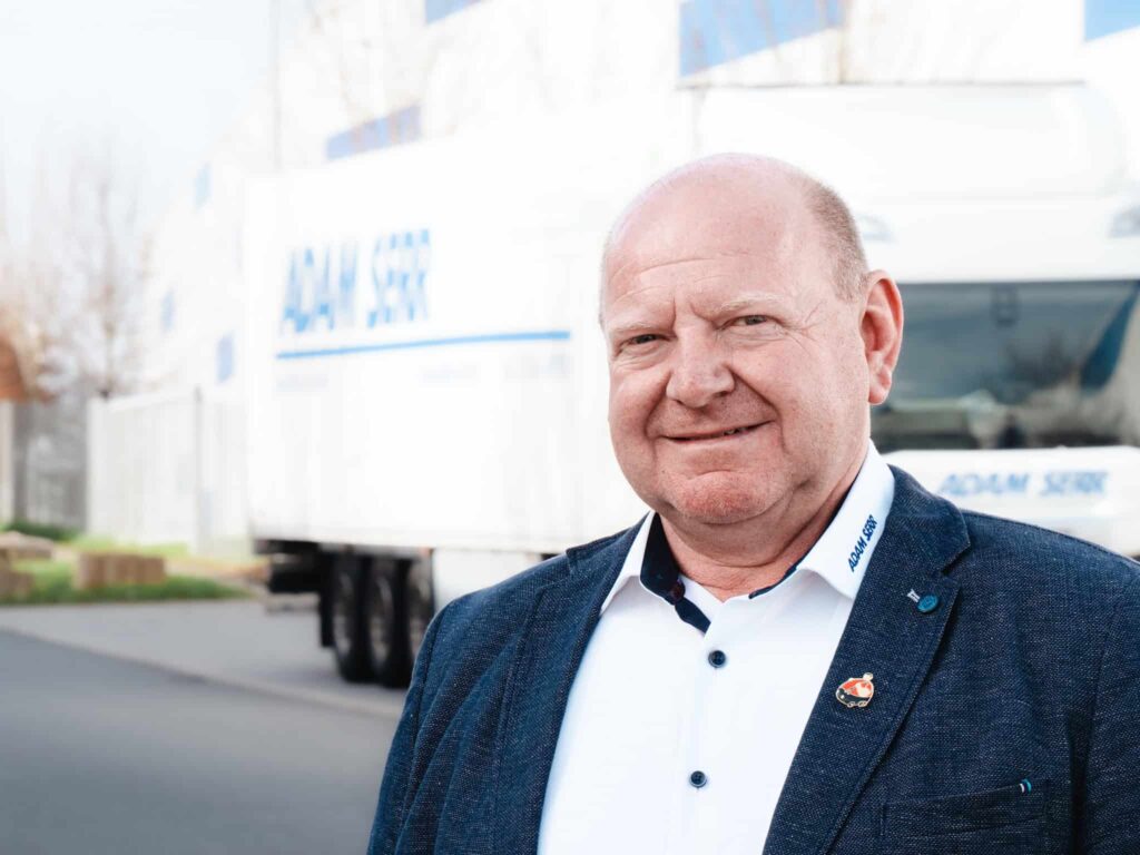 Prokurist Albert Bolinth vor E-LKW von Adam Serr
